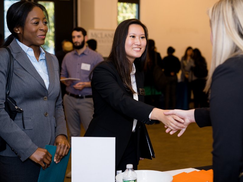 A law student shakes hands with an employer at the BBA Career Fair