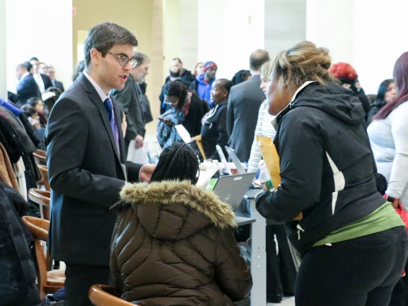 A volunteer attorney speaks with community members seeking legal help at a pro bono clinic